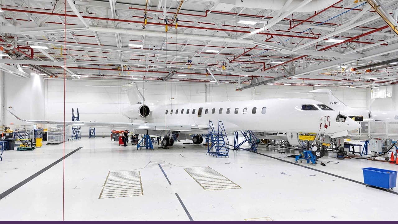 Commercial aircraft undergoing maintenance inside large industrial aviation hangar
