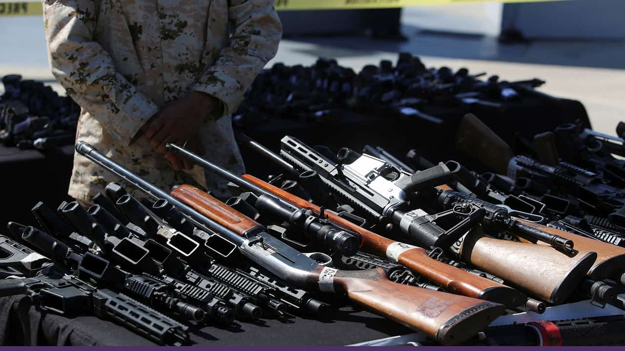 Confiscated firearms displayed on table during security operation evidence
