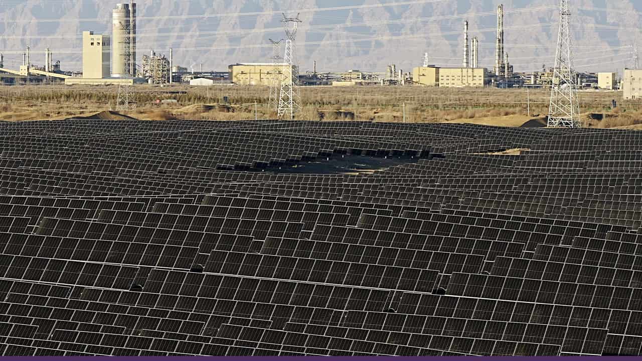 Large solar panel field near industrial buildings