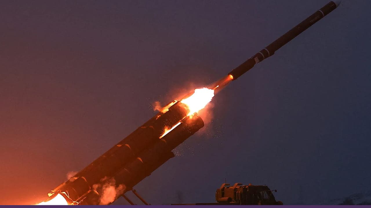 A missile launches into the sky at dusk, with bright flames and sparks shooting from its base as it lifts off from a ground-based launcher.