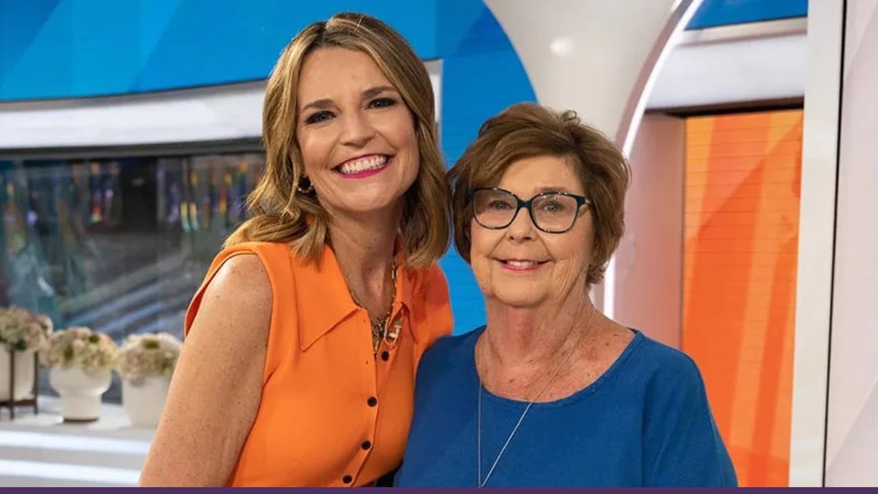 Television anchor smiles beside elderly woman inside studio set
